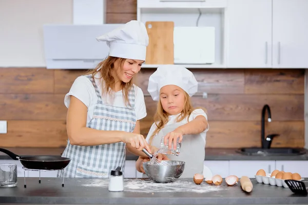 Glad kaukasisk mor och dotter bakar tillsammans i köket — Stockfoto
