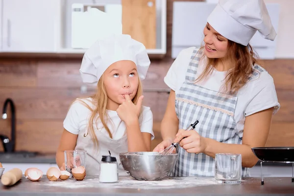 Funny mother and daughter making dough for baking — Stock Photo, Image