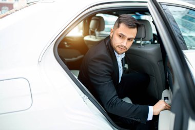 Arabadan çık. Beyaz arabasından inen adama yan bakış