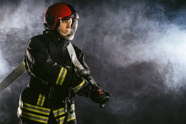 Modern kahramanlar. Genç itfaiyeci duman içinde.