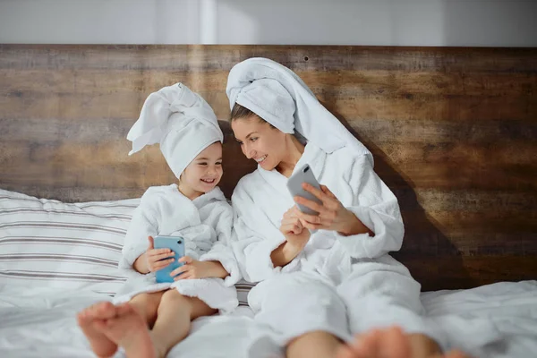 Jong Kaukasisch moeder met dochter gebruik smartphone — Stockfoto