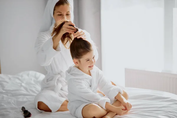 Attractive mother and daughter on bed after shower — Stock Photo, Image