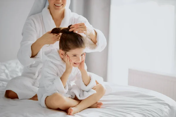 Mamá atar la cola en hijas cabello —  Fotos de Stock