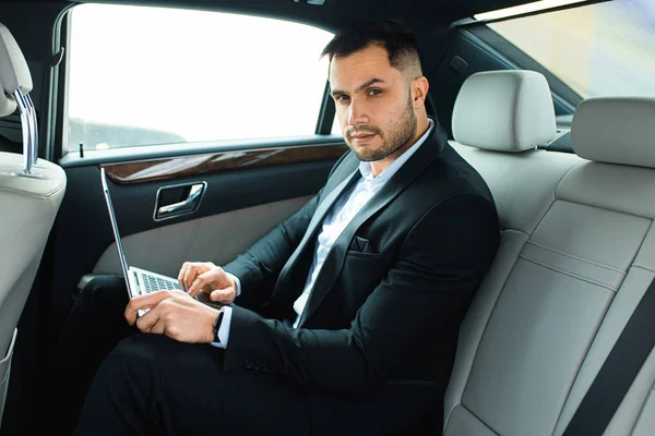 Porträt eines jungen kaukasischen Geschäftsmannes in einem teuren Auto — Stockfoto