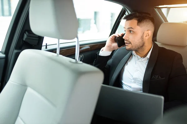 Sympathischer selbstbewusster Mann im Smoking telefoniert im Auto — Stockfoto