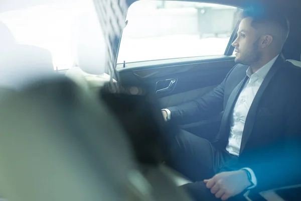 Side view on busy man sitting in his own new car — Stock Photo, Image