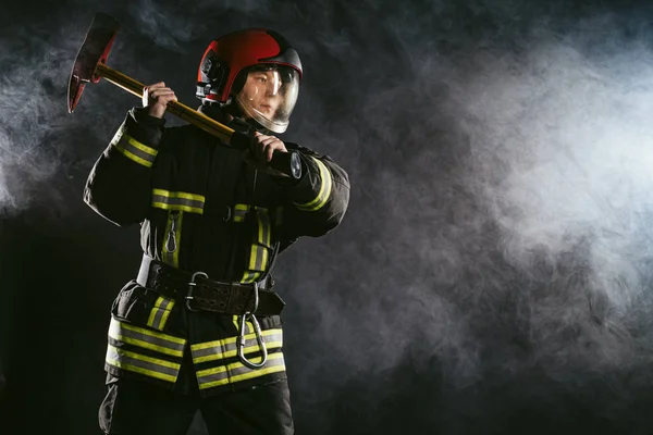 Feuerwehrmann mit Hammer hat keine Angst vor Gefahr und Feuer — Stockfoto