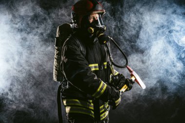 Güçlü itfaiyeci dumanlı arka planda izole edildi