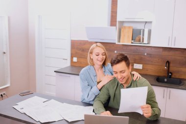 pozitif adam ve kadın dizüstü bilgisayardan banka hesaplarını kontrol ediyorlar