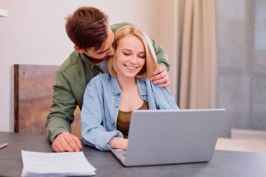 Sevimli çift, evdeki masada birlikte oturuyorlar.