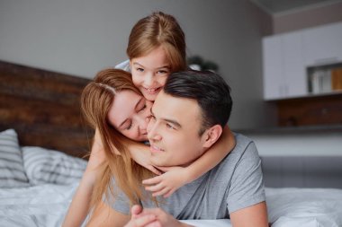 Yatakta genç bir ailenin portresi