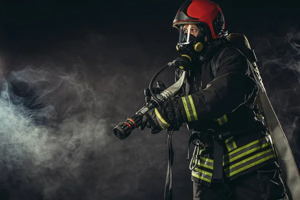 Heróis modernos. jovem bombeiro isolado na fumaça — Fotografia de Stock