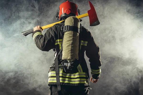 Rear view on fireman in smoke — Stock Photo, Image