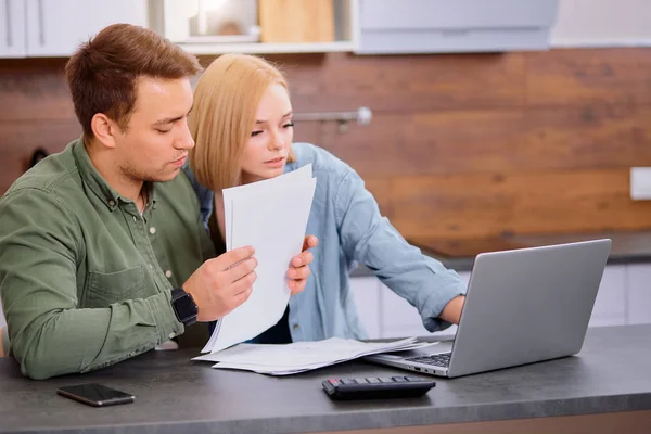 Focado jovem casal caucasiano verificando analisando contas de utilidades em casa — Fotografia de Stock