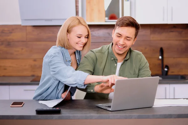 Kaukasische junge Ehepartner sitzen mit Laptop und Dokumenten zu Hause — Stockfoto