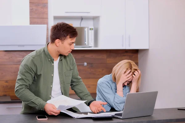 Aggódó fiatal pár segítségével laptop megoldása pénzügyi problémák otthon — Stock Fotó