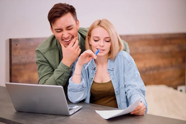 Χαμογελαστό ζευγάρι κάθονται μαζί χρησιμοποιώντας φορητό υπολογιστή στο σπίτι — Φωτογραφία Αρχείου