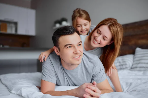 Retrato de la familia joven en la cama — Foto de Stock