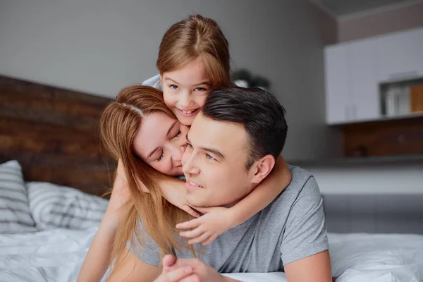 Retrato de la familia joven en la cama — Foto de Stock