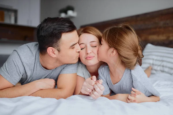 Retrato de bela família sorridente na cama — Fotografia de Stock