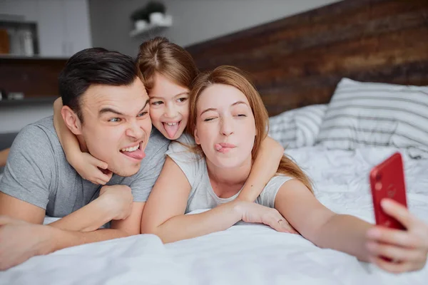 Ελεύθερος χρόνος της καυκάσιας οικογένειας ξαπλωμένος στο κρεβάτι — Φωτογραφία Αρχείου