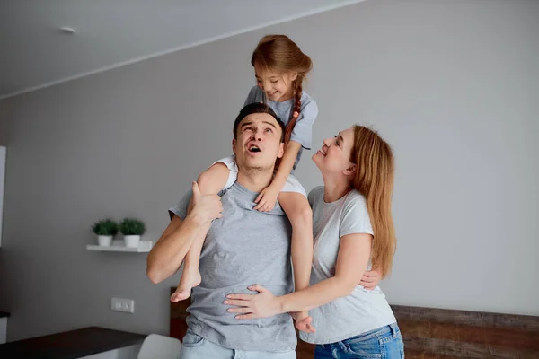 Genitori attraenti e figlia in posa a casa — Foto Stock