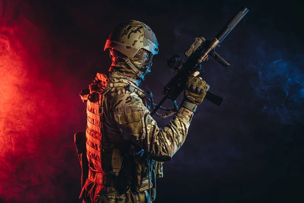 Guerreiro homem em uniforme militar em fundo fumegante com raios UV — Fotografia de Stock