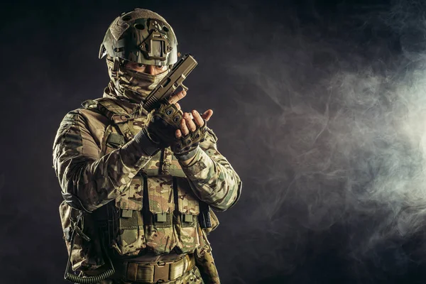 Musculoso joven soldado en ropa de ejército con pistola — Foto de Stock
