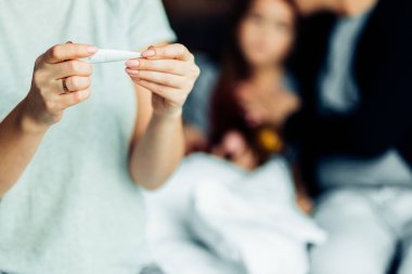 Kırpılmış genç kadın termometreyi tutuyor