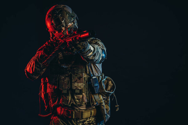 молодой военный, направляющий оружие на врага
