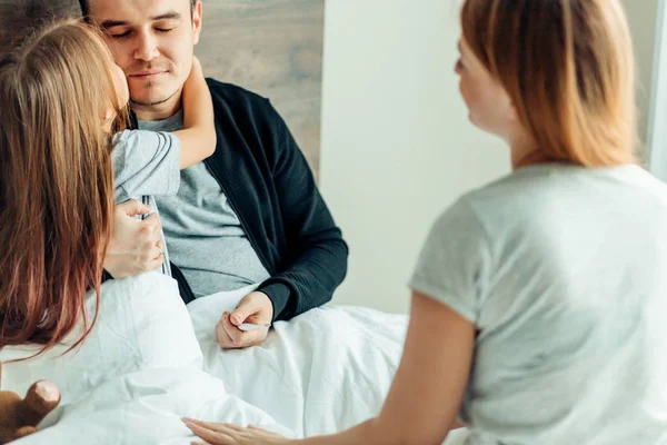 Familia feliz en la cama sufriendo de frío — Foto de Stock