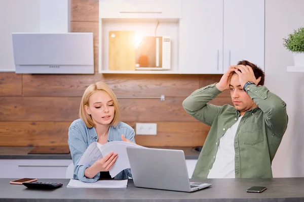 Беспокойная молодая пара с помощью ноутбука решения финансовых проблем на дому — стоковое фото