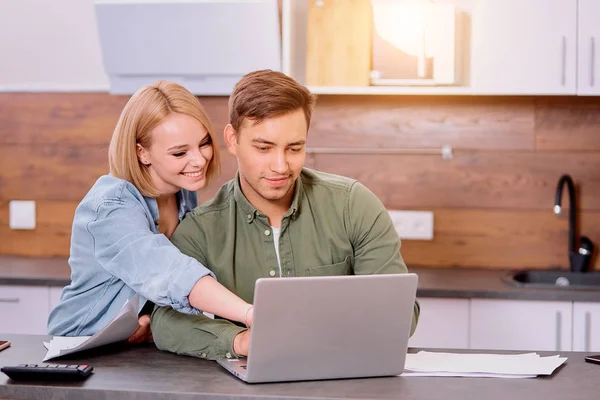 Encantador casal positivo verificando suas finanças em casa — Fotografia de Stock