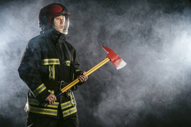 Orta yaşlı itfaiyeci git ve insanları yangından koru.