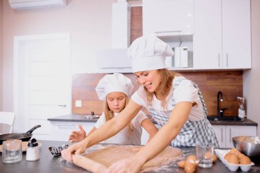 Küçük kız annesiyle para kazanıyor.