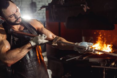 Kafkasyalı genç demirci demircideki erimiş metali dövüyor ve şuna bak.