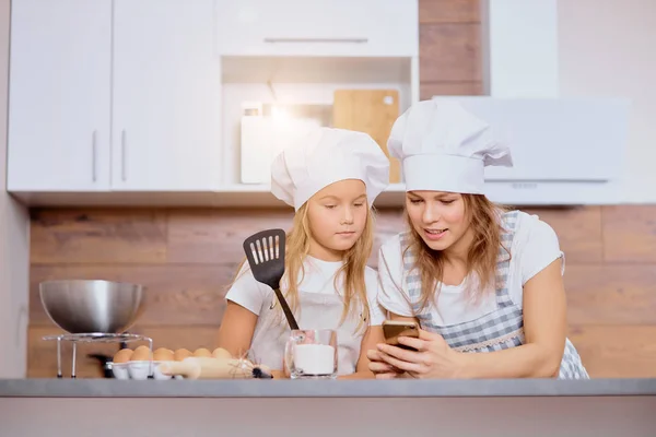 Madre caucasica e bambino guardano lo schermo dello smartphone prima di cucinare — Foto Stock