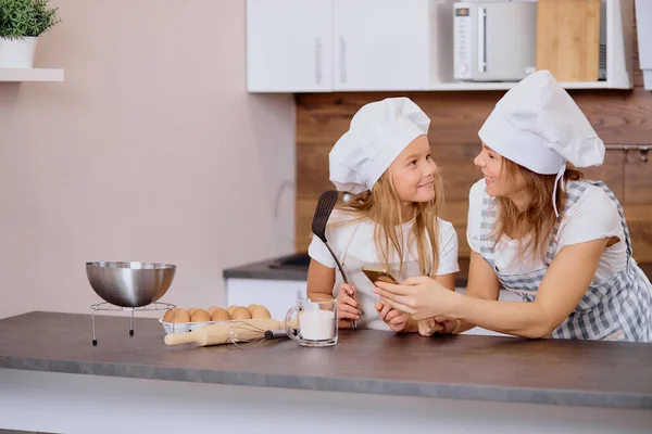 Mulher adorável com filha vai cozinhar — Fotografia de Stock