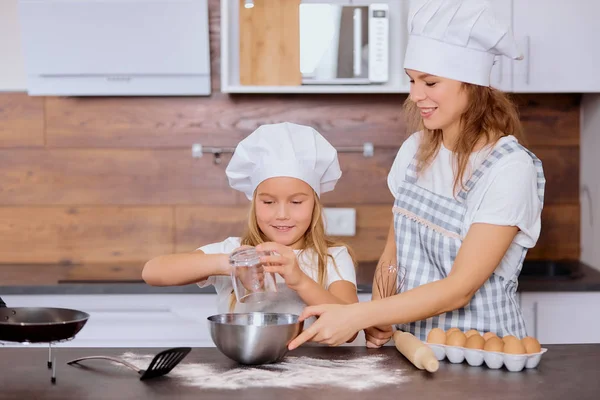 Positives Kind streut Mehl in Küche — Stockfoto