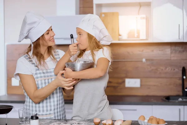 Grappige moeder en dochter maken deeg voor het bakken — Stockfoto