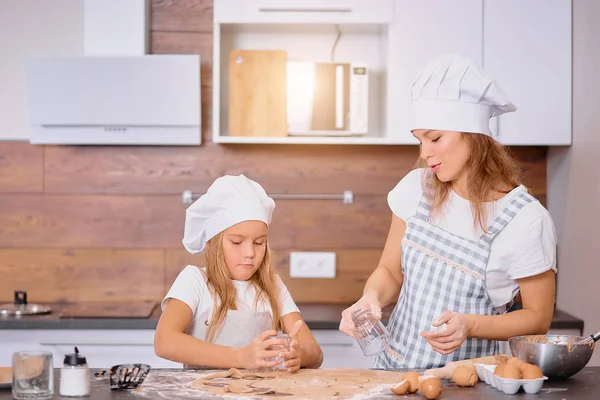 Junge kaukasische Mutter bringt kleinen Mädchen das Backen bei — Stockfoto