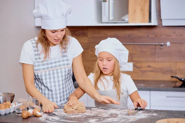 Little girl making dough with mother — Stock Photo, Image