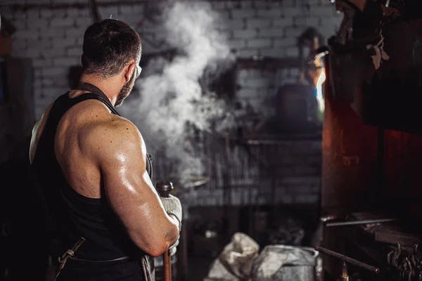 Unrecognizable muscular blacksmith in workshop — Stock Photo, Image