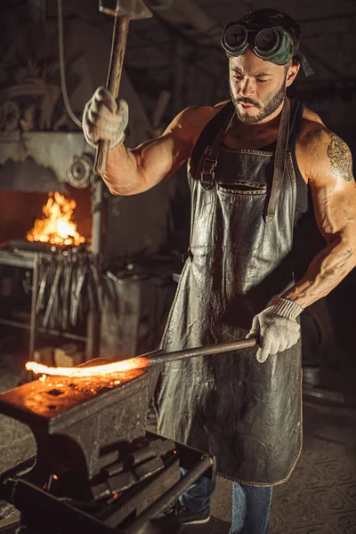 Hombre fuerte trabajando con martillo aislado en taller —  Fotos de Stock