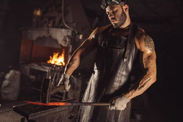 Hombre fuerte trabajando con martillo aislado en taller —  Fotos de Stock