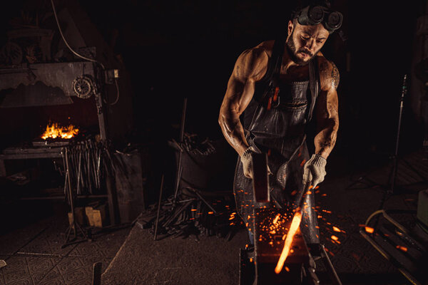 young blacksmith forging molten metal