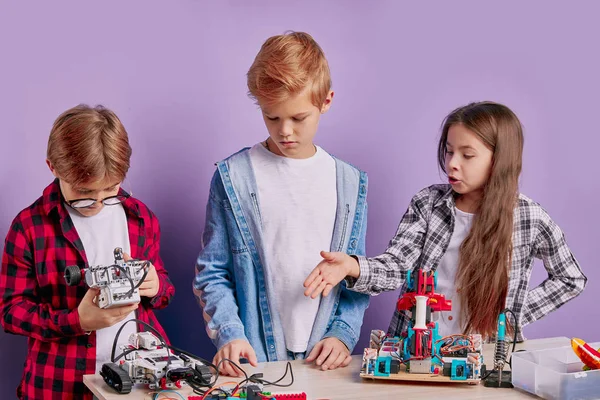 Entusiastiska berörda barn montera tech robotar, framtida ingenjörer — Stockfoto