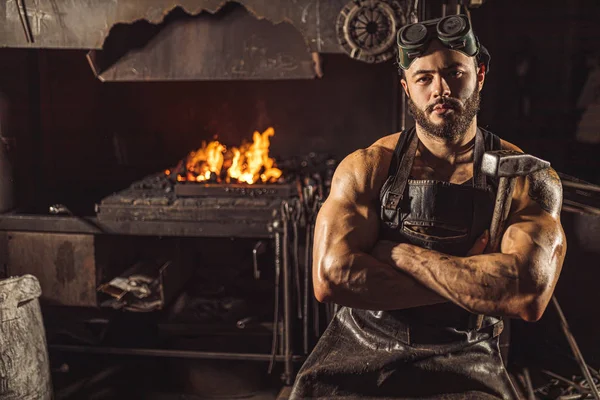 黒エプロンに自信を持って強い若い金属労働者の肖像画 — ストック写真
