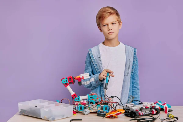 Портрет увлеченного мальчика, занимающегося сборкой роботов в инженерном клубе — стоковое фото