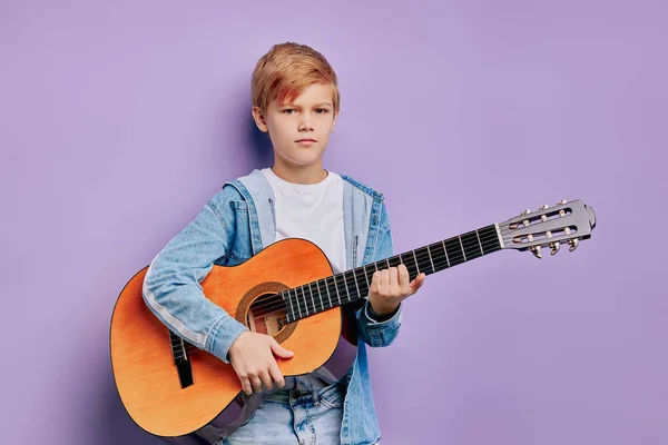 Gitar çalan çocuk mor arka planda izole edilmiş. — Stok fotoğraf